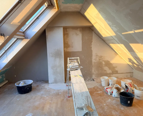 Dachgeschoss im Ausbau mit frisch gespachtelten Wänden und Schrägen